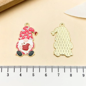 Detail view of gnome enamel pendants with measurements shown on a measuring scale