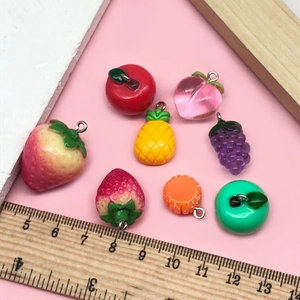 Gros plan de pendentifs fruits 3D en résine avec anneaux métalliques pour bijoux DIY