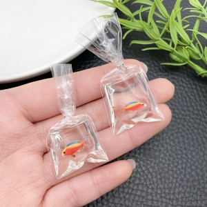 Detail view of creative resin goldfish in water bag charm with metallic ring hook