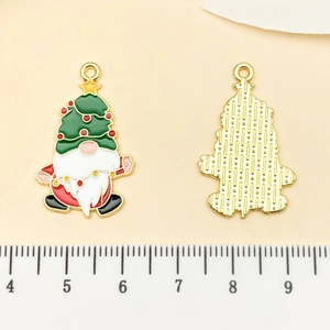 Macro shot of Christmas gnome pendant showing colorful enamel front and textured gold back