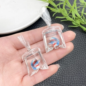 Detailed close-up of handmade resin goldfish earrings in clear bag charms with silver hooks