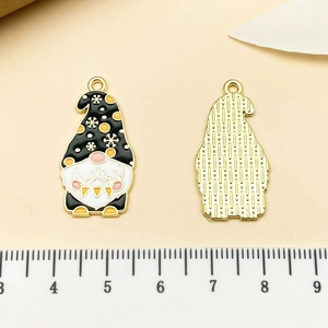 Macro view of Christmas gnome enamel pendants showing front details and metallic back