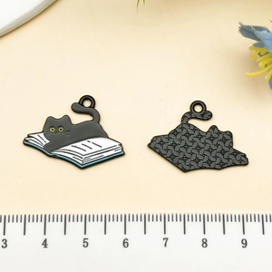Détail du pendentif chat lisant un livre montrant l'émail avant et la texture arrière