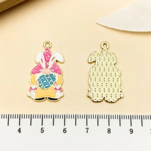 Detail view of gnome pendant with bunny ears and Easter egg next to a metric scale