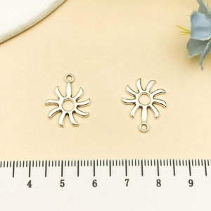 Macro detail of sun-shaped alloy pendant connectors with radial design for DIY jewelry