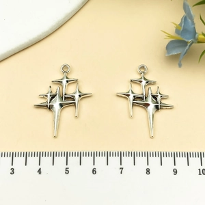 Close-up of silver star charms with a measuring ruler for DIY jewelry making