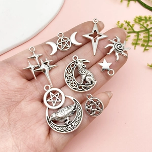 Antique silver star and moon pendants for DIY jewelry making shown in hand