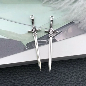 Detailed macro view of antique silver sword pendants for DIY jewelry and bookmarks