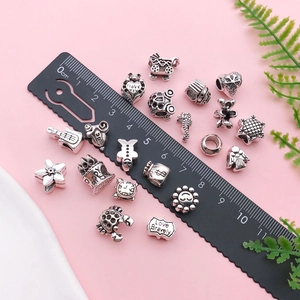 Close-up of assorted Tibetan silver large hole beads for DIY jewelry with ruler scale
