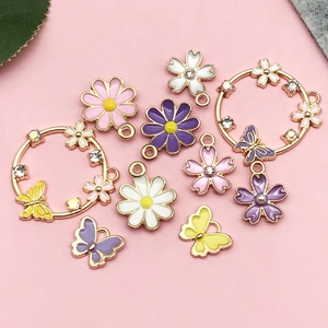 Detailed view of colorful enamel butterfly and floral pendants for DIY jewelry design