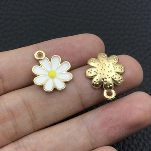Detailed close-up of a white daisy pendant with yellow core and golden metal texture