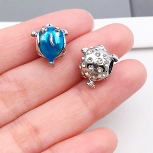 Dettaglio dei ciondoli a forma di tartaruga con smalto blu e strass bianchi per fai-da-te