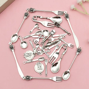 Macro detail of vintage silver alloy miniature cutlery charms for DIY jewelry making