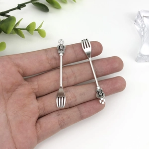 Detailed view of silver crown forks in palm showing realistic size and vintage texture