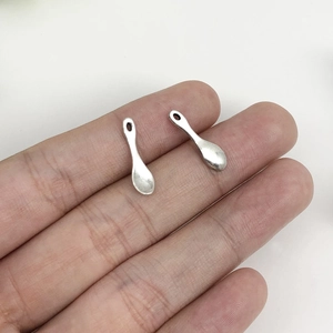 Macro shot showing small silver alloy spoon charms for DIY jewelry and keychains