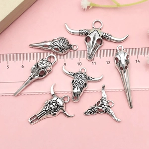 Gros plan de pendentifs crâne d'animal en alliage vintage avec détails gravés et patine