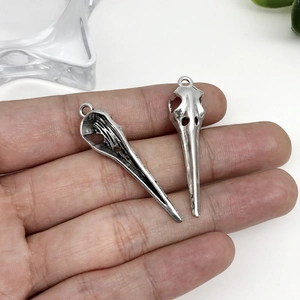 Détail de deux pendentifs crâne d'oiseau en alliage argent antique avec anneaux