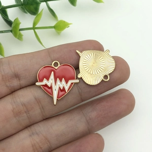 Dettaglio di ciondoli a cuore con motivo ECG e smalto rosso per gioielli fai-da-te