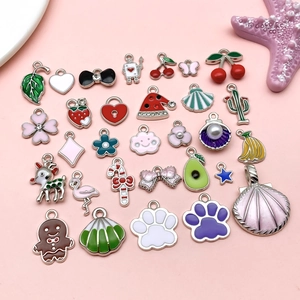 Flat lay of colorful enamel fruit and animal charms with silver finish for DIY jewelry