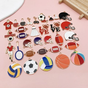 Flat lay of colorful enamel sports charms including soccer and basketball for DIY jewelry
