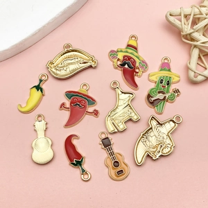 Mexican style enamel cactus and chili pendants with golden plating on pink background
