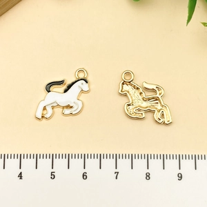 Vue détaillée recto-verso de pendentifs chevaux émaillés avec règle de mesure