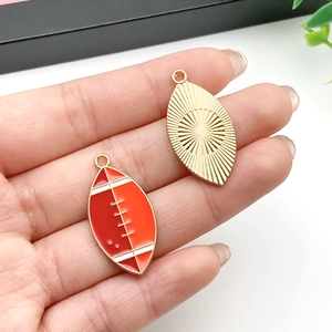 Nahaufnahme beidseitiger Rugby-Ball Anhänger mit Emaille und goldener Metallrückseite für DIY