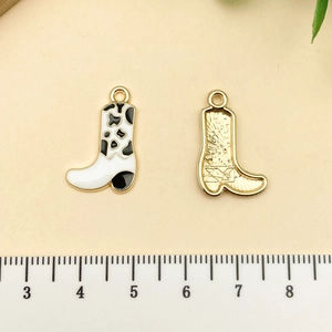 Détail du pendentif botte de cow-boy avec motif vache, dorure et échelle de mesure