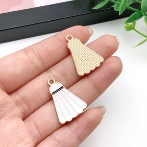 Makro-Detail von DIY-Badminton-Anhängern mit weißer Emaille und Goldbeschichtung