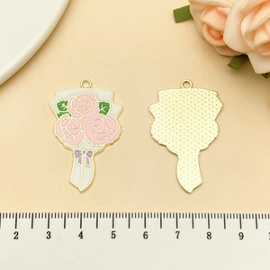 Vue détaillée de pendentifs bouquet de fleurs en émail rose avec bords dorés
