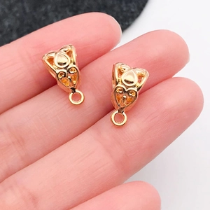 Vista macro de cuentas de tubo curvo en oro KC con patrones huecos para joyería DIY