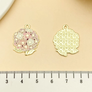 Détail de breloques bouquet de fleurs avec émail rose et dos doré à motif d'étoiles