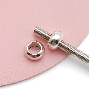 Vista macro di una perla distanziatrice argentata a foro largo per bracciali DIY