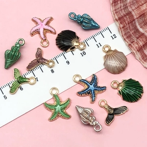 Macro detail of colorful ocean shell and starfish charms with ruler for size reference