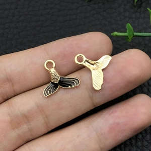 Macro shot of gold and black enamel mermaid tail pendants for DIY jewelry making