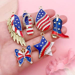 Hand holding US flag themed DIY jewelry pendants in wing, boot, and star shapes