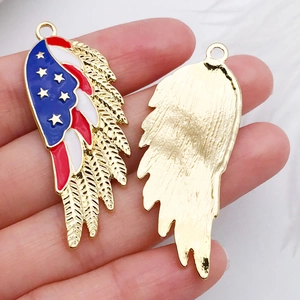 Close-up of golden wing pendants with US flag enamel pattern and textured back