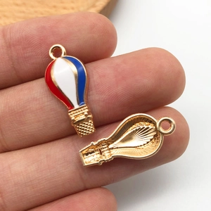 Macro shot of hot air balloon charm with red white blue enamel and gold plating