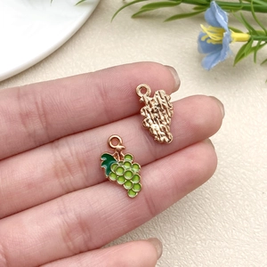 Close-up of DIY grape charms with green enamel finish and gold textured back details