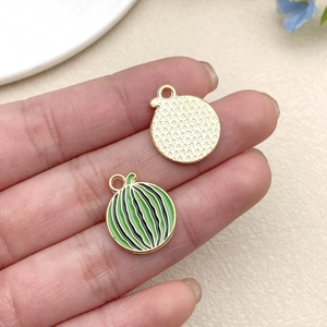 Macro detail of watermelon enamel charms with star pattern and golden back for DIY jewelry