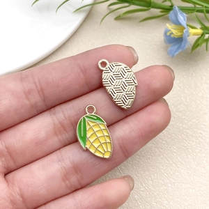 Detailed view of corn enamel charms for DIY earrings showing both front and back sides