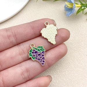 Detailed close-up of a purple grape-shaped alloy pendant with gold plating and enamel