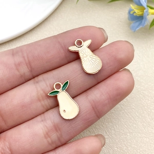 Macro detail of pear-shaped enamel pendants with gold backing and fine metal texture