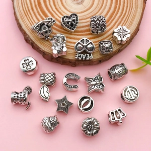 Dettaglio di ciondoli in argento vintage con motivi a cuore e corona per bracciali fai-da-te