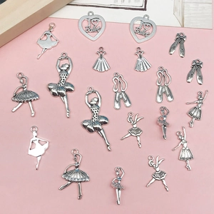 Colgantes de ballet en plata vintage con zapatos y bailarinas sobre fondo rosa