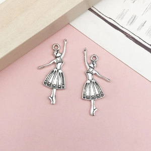 Vista macro de dos colgantes de bailarina de plata antigua para hacer joyas DIY