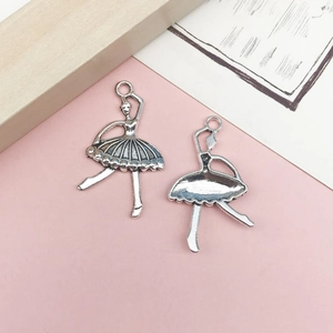 Primer plano de dos dijes de bailarina en plata antigua para joyas personalizadas