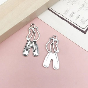 Detalle de dijes de zapatillas de ballet en plata antigua para la creación de joyería DIY
