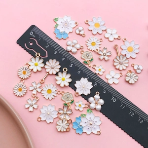 Vue détaillée de pendentifs fleurs en émail faits à la main avec échelle centimétrique