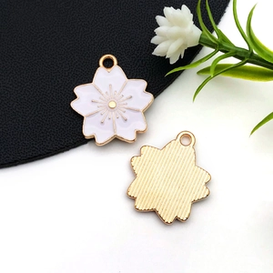 Détail du pendentif fleur de cerisier en émail rose et finition dorée pour bijoux DIY
